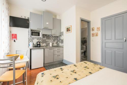 a kitchen with white cabinets and a table and a door at A Francos Burguer Station 2 in Porto