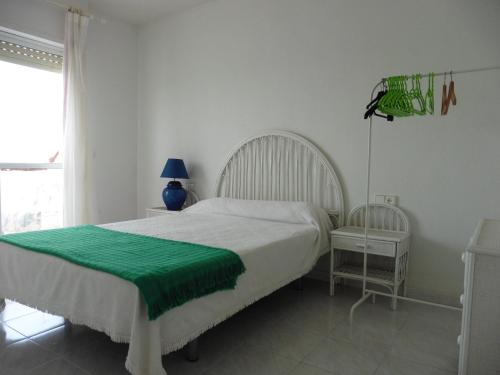 - une chambre avec un lit doté d'une couverture verte dans l'établissement Ibicencos, à La Manga del Mar Meno
