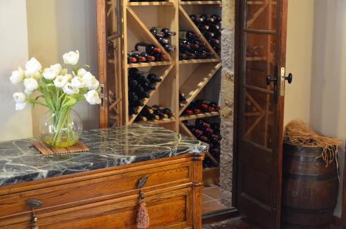 a wine cellar with a vase of flowers on a counter at Hotel Galena Mas Comangau in Begur
