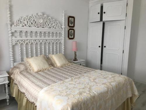 a bedroom with a white bed with a white headboard at Vivenda Azevedo in Nazaré