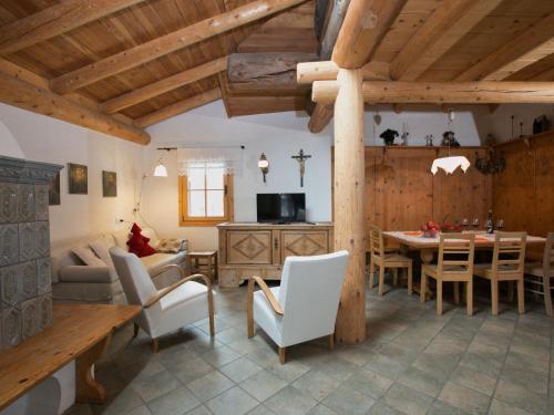 a kitchen and living room with a table and chairs at Apartment in a typical baita in the Dolomites with sauna and Turkish bath in Bellamonte