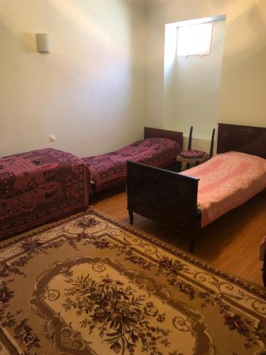a room with two beds and a rug at Armen's Guest House in Tatʼev