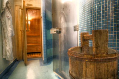 baño con bañera de madera antigua y azulejos azules en Villa Novecento Romantic Hotel - Estella Hotel Collection en Courmayeur