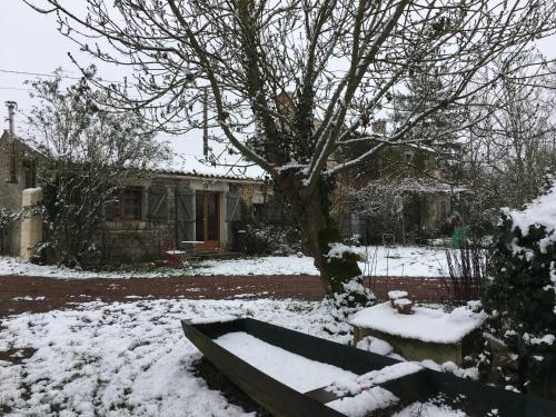 einen schneebedeckten Hof vor einem Haus in der Unterkunft Dormir Ben Aise Hammam Massages in Maillezais