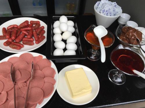 a table with plates of meat and eggs and other foods at Göcek Centre Hotel in Göcek