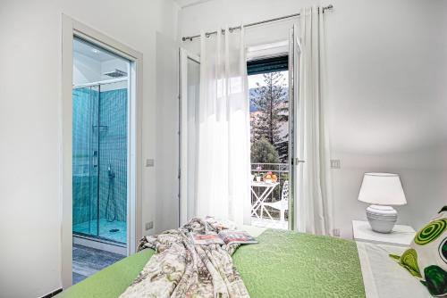 een slaapkamer met een groen bed en een groot raam bij I colori di Sorrento in Sorrento