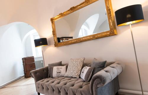 a living room with a couch and a mirror at Apartments Hoferhaus - Your Austrian Home in Bad Aussee