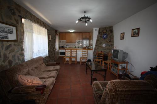 sala de estar con sofá y mesa en Casa Rural el Huerto, en Solana de Ávila