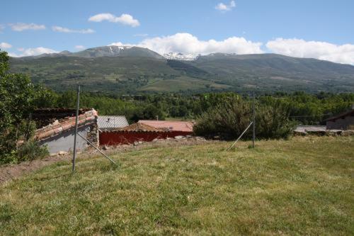 un campo de hierba con una montaña en el fondo en Casa Rural el Huerto, en Solana de Ávila