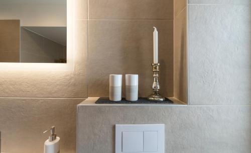 a bathroom with a candle on a shelf with a sink at Apartments Hoferhaus - Your Austrian Home in Bad Aussee
