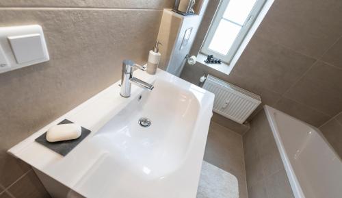 a white sink in a bathroom with a window at Apartments Hoferhaus - Your Austrian Home in Bad Aussee
