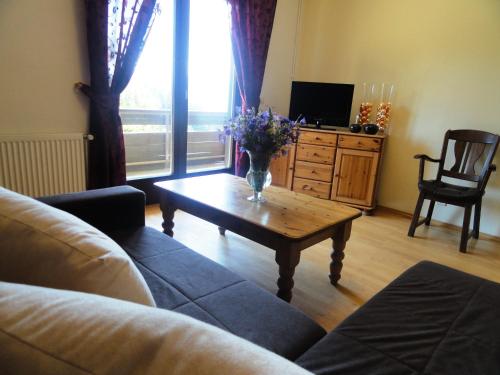a living room with a couch and a table with flowers on it at Landhaus Bonaventura in Millstatt