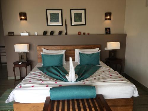 a bedroom with a large bed with green pillows at Twenty-Two Weligambay in Weligama