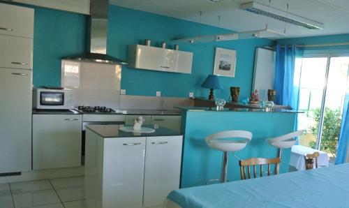 eine Küche mit blauen Wänden und weißen Schränken in der Unterkunft Appartement Annie LLENSE in Argelès-sur-Mer