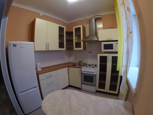 ペルミにあるApartments on Krasnova 25の小さなキッチン(白いキャビネット、白い冷蔵庫付)