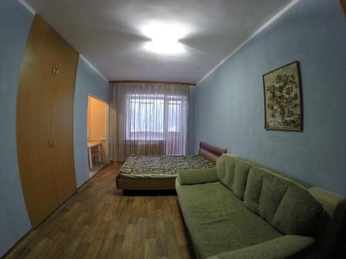 ペルミにあるApartments on Krasnova 25のソファとベッドが備わる客室です。