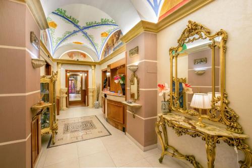 ein Badezimmer mit einem goldenen Spiegel und einem Waschbecken in der Unterkunft Hotel Forte in Rom