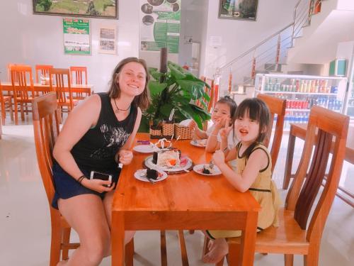 a woman and two girls sitting at a table at An Binh Homestay in Phong Nha