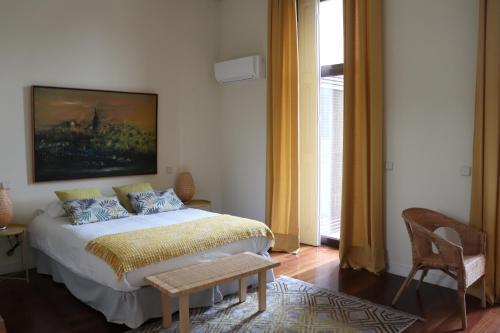 a bedroom with a bed with a painting on the wall at OHH - Porto Boutique Guest House in Porto