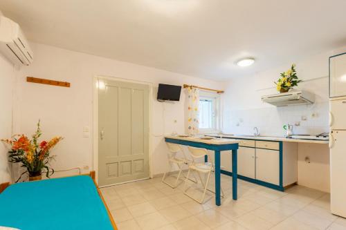 a kitchen with a blue table and a blue counter at Ormos Drepanou Apartments in Lygia