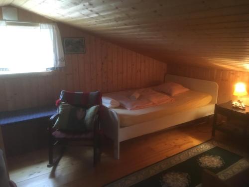 1 dormitorio pequeño con 1 cama y 1 silla en Holiday Home Sondre Hallangen, en Fagerstrand