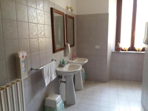 a bathroom with two sinks and a mirror at ostello ortensi in Farnese
