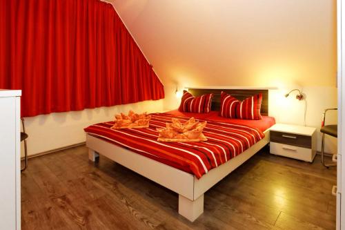 a bedroom with a large bed with red curtains at Lotsenstieg 03 in Ostseebad Karlshagen