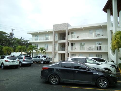 a car parked in a parking lot in front of a building at Kitewind Apartamentos Cabarete in Cabarete