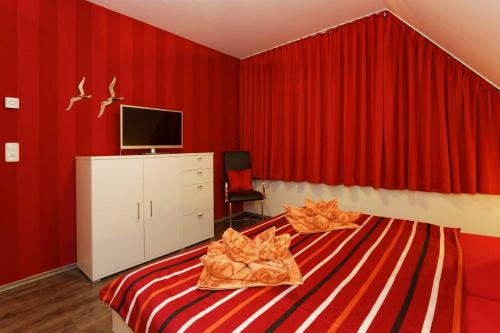 a red bedroom with a bed with red curtains at Lotsenstieg 03 in Ostseebad Karlshagen