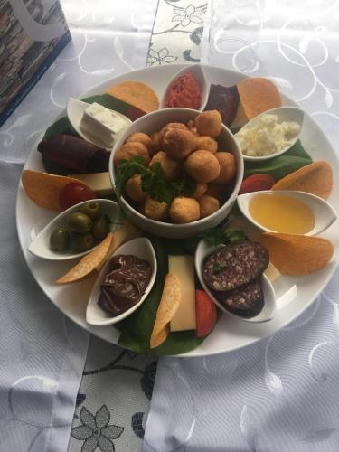a plate of different types of food on a table at B&B Hisar International in Prijepolje