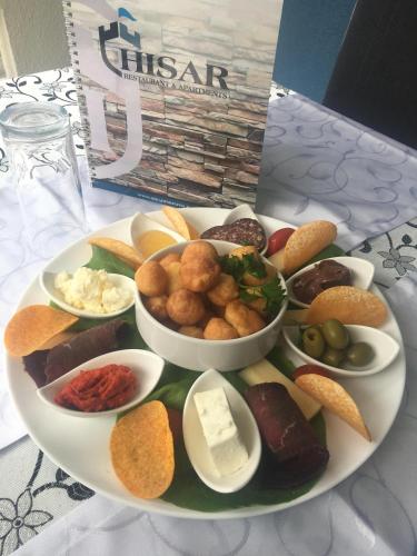 a plate with different types of food on a table at B&B Hisar International in Prijepolje