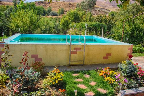 a swimming pool in a garden with flowers at Ashot & Gohar B&B in Chʼiva