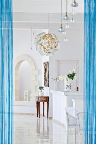 a dining room with a table and a chandelier at Mrs Chryssana Beach Hotel in Kolymvari