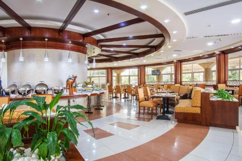 a restaurant with a large lobby with tables and chairs at Sharjah Premiere Hotel & Resort in Sharjah
