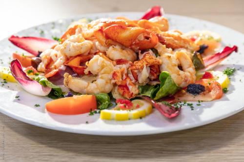a plate of shrimp and vegetables on a table at LOGIS Hôtel & Restaurant - LENSOTEL in Lens
