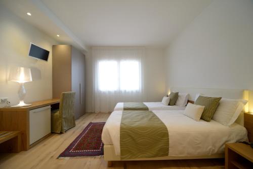 a bedroom with a bed and a desk and a window at Hotel Ristorante Da Tullio in Tarzo
