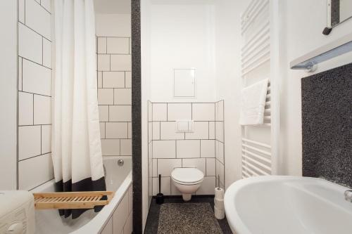 a white bathroom with a toilet and a sink at 3 Bedroom Apartment (ACERE) in Berlin