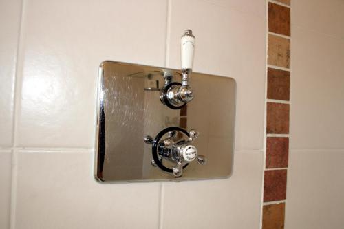 a toilet paper dispenser on a wall in a bathroom at Upper Neatham Mill in Alton