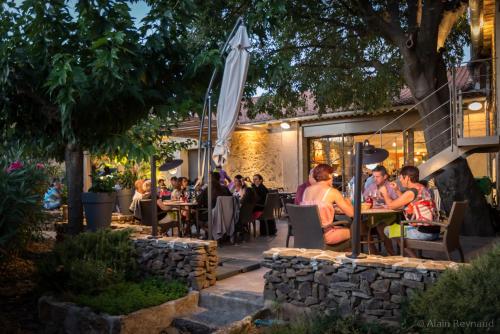 a group of people sitting at tables outside a restaurant at Abbaye Sylva Plana in Laurens