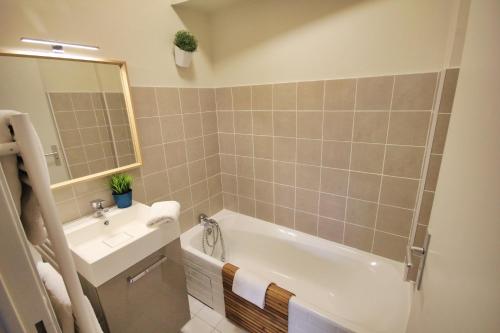 une salle de bain avec une baignoire blanche et un lavabo dans l'établissement Limas - Appartement Avignon centre, à Avignon