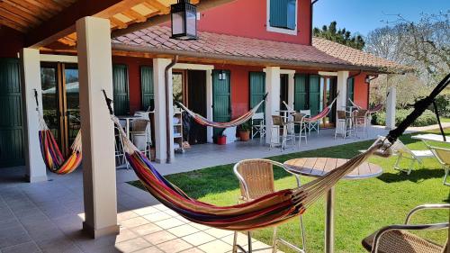 a house with two hammocks on a patio at Hotel La Posta di Torrenova in Orbetello