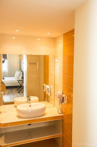 a bathroom with two sinks and a mirror at Abbaye Sylva Plana in Laurens