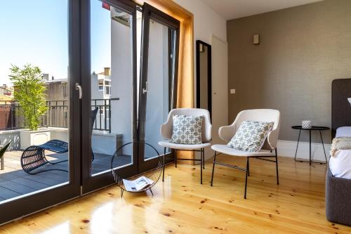 a living room with two chairs and a balcony at Formosa 178 by Guestify in Porto