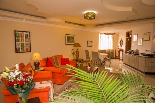 a living room with an orange couch and a table at Hotel Rudi in Nairobi