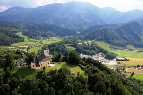 a house on a hill with mountains in the background at Ferienhof Unterführholzergut in Klaus