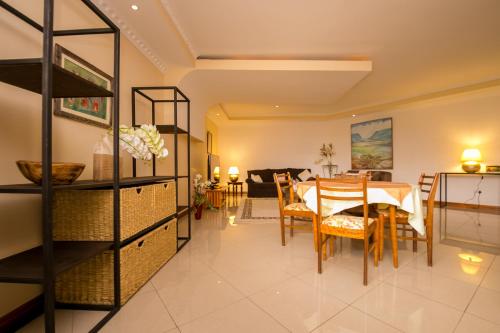 a dining room and living room with a table and chairs at Hotel Rudi in Nairobi