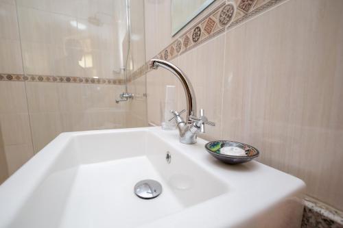 a white sink in a bathroom with a shower at Hotel Rudi in Nairobi