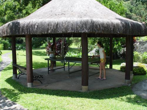 a woman standing in a gazebo with a table at Auberge Suisse Pousada in Nova Friburgo