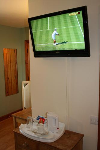 a television hanging on a wall with a tennis game at Upper Neatham Mill in Alton