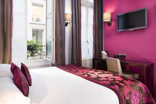 パリにあるHôtel Paris Louvre Opéraの紫の壁のベッドルーム1室(白いベッド1台付)